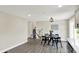 Open-concept dining area with modern light fixture, wood-look flooring, and view of the staircase at 1944 Galeston Ct, Indianapolis, IN 46229