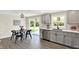 Kitchen with gray cabinets, stainless steel dishwasher, and a dining area with modern black chairs at 1944 Galeston Ct, Indianapolis, IN 46229