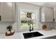 Bright kitchen featuring gray cabinets, subway tile backsplash, and a black sink with a spring faucet at 1944 Galeston Ct, Indianapolis, IN 46229
