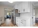 Bright kitchen featuring white cabinetry, stainless steel refrigerator, and a view into the living room at 2006 N Moreland Ave, Indianapolis, IN 46222