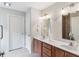 Bathroom features a double vanity with wood cabinets, tile floors, and framed mirror at 217 Devonshire Ct, Anderson, IN 46013