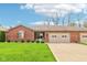 Charming brick home featuring a well-manicured lawn and an attached two-car garage at 217 Devonshire Ct, Anderson, IN 46013