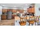 The open kitchen features an eat-in bar, stainless steel appliances, and wood cabinetry at 217 Devonshire Ct, Anderson, IN 46013