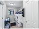 Functional laundry room equipped with washer, dryer, utility sink, and storage shelving at 217 Devonshire Ct, Anderson, IN 46013