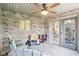 Relaxing sunroom with brick walls, neutral carpet, ceiling fan, and sliding glass door at 217 Devonshire Ct, Anderson, IN 46013