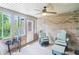 Enclosed sunroom featuring brick walls, neutral carpet, fan, and comfortable seating at 217 Devonshire Ct, Anderson, IN 46013