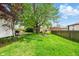 Spacious backyard with lush green grass, mature trees, wooden privacy fence, and a shed at 218 Pearl St, Fortville, IN 46040
