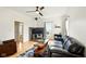 Well-lit living room with hardwood floors, a black slate fireplace, and a comfortable leather couch at 218 Pearl St, Fortville, IN 46040