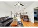 Spacious living room with hardwood floors, a leather sofa, and a dining table near the window at 218 Pearl St, Fortville, IN 46040