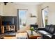 Inviting living room features hardwood floors, a black slate fireplace, and two large windows at 218 Pearl St, Fortville, IN 46040