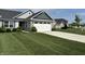 A beautiful home exterior showcasing a spacious lawn and a driveway leading to a two-car garage at 230 Kiawah Dr, Whiteland, IN 46184