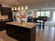 Modern kitchen showcasing an island with granite countertop and stainless steel appliances at 230 Kiawah Dr, Whiteland, IN 46184
