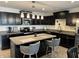 Modern kitchen with black cabinetry, stainless steel appliances, and a granite countertop island with seating at 230 Kiawah Dr, Whiteland, IN 46184