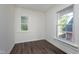 Empty room with dark wood-look floors and windows looking out on a sunny day at 2442 Guilford Ave, Indianapolis, IN 46205