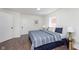 Cozy bedroom with a striped comforter, wood-look floors, bedside lamp and side table at 2442 Guilford Ave, Indianapolis, IN 46205