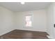 A bedroom features wood-look floors and a bright window looking out on a sunny day at 2442 Guilford Ave, Indianapolis, IN 46205