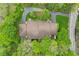 Aerial view of a well-maintained brown roof home with lush greenery, surrounded by trees at 2922 Amherst St, Indianapolis, IN 46268