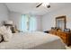 Cozy bedroom with a ceiling fan, window with blue curtains, light walls, and neutral comforter at 2922 Amherst St, Indianapolis, IN 46268