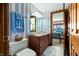 Charming bathroom with striped wallpaper, wood vanity, and view to a bedroom at 3107 Waterfront Cir, Anderson, IN 46012