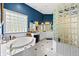 Bright bathroom with a soaking tub, glass block window, and white cabinetry at 3107 Waterfront Cir, Anderson, IN 46012
