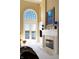 Bright living room features a fireplace, arched window, and balcony access with lovely water views at 3107 Waterfront Cir, Anderson, IN 46012
