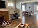 Inviting living room featuring hardwood floors, a fireplace, and an open dining area at 36 N Ewing St, Indianapolis, IN 46201