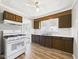 Well-lit kitchen with wood cabinets, gas range, vinyl floors, and white appliances at 3631 Columbus Ave, Anderson, IN 46013