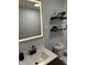 Modern bathroom with a well lit mirror, updated fixtures, floating shelves, and decorative elements at 3720 W 16Th St, Indianapolis, IN 46222