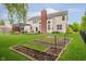 Spacious backyard with lush green lawn, garden beds, and a pergola for outdoor entertaining at 3743 Earhart Dr, Carmel, IN 46074