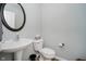 Cozy powder room features a pedestal sink, oval mirror, and a toilet with tissue storage at 3743 Earhart Dr, Carmel, IN 46074