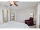 Bright bedroom featuring a ceiling fan, chair, and a view of the upstairs landing at 3743 Earhart Dr, Carmel, IN 46074
