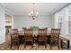 Formal dining room featuring a long wooden table, a chandelier, and large windows at 3743 Earhart Dr, Carmel, IN 46074