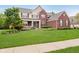 Charming two-story brick home featuring a welcoming front porch and lush green lawn at 3743 Earhart Dr, Carmel, IN 46074