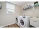 Well-lit laundry room with modern washer, dryer, utility sink, and shelving storage at 3743 Earhart Dr, Carmel, IN 46074