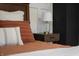 Close up of bedroom with modern nightstand, decorative lamp, and orange striped pillows at 4244 Rookwood Ave, Indianapolis, IN 46208