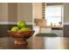 Close-up of dining table shows fruit centerpiece with view of kitchen beyond at 4244 Rookwood Ave, Indianapolis, IN 46208
