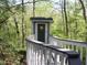 Outhouse in the forest with gray door, sun symbol, and bridge access at 4363 E State Road 252, Franklin, IN 46131