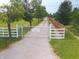 Enter the property through an elegant gate with a private driveway, surrounded by lush greenery at 4363 E State Road 252, Franklin, IN 46131