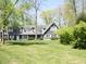 This home is nestled amongst trees with green lawn, showcasing its curb appeal at 4363 E State Road 252, Franklin, IN 46131