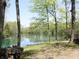 Scenic lake view framed by mature trees, with a stack of firewood in the foreground at 4363 E State Road 252, Franklin, IN 46131