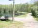 Lakeside scene featuring a small boat, dock, and gravel pathway, enhancing the property's charm and accessibility at 4363 E State Road 252, Franklin, IN 46131