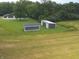 Two storage buildings on a well-maintained lawn surrounded by trees, providing ample space for equipment or hobbies at 4363 E State Road 252, Franklin, IN 46131