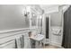 Well-lit bathroom featuring a pedestal sink, medicine cabinet, wainscoting, and separate storage cabinet at 440 W Marion St, Danville, IN 46122