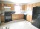 A functional kitchen with wooden cabinets and black appliances, ready for your personal touch at 470 N Pine St, Morgantown, IN 46160