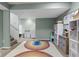 Finished basement area with a rainbow rug, white storage cabinets, and olive green walls at 4749 Maple Grove Rd, Martinsville, IN 46151