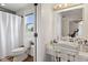 Bright bathroom featuring a toilet and vanity with decorative chair and lighting at 4749 Maple Grove Rd, Martinsville, IN 46151
