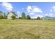 Picturesque home exterior with a spacious lawn, barn, and mature trees under a bright blue sky at 4749 Maple Grove Rd, Martinsville, IN 46151