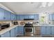 Modern kitchen with stainless steel appliances, light counter tops, and blue cabinets at 48 W Adams Brick Ave, Martinsville, IN 46151