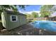 View of the in-ground swimming pool, storage shed and fenced yard on a sunny day at 492 Pelenor Dr, Franklin, IN 46131