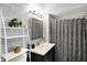 Well-lit bathroom with a modern vanity, decorative shelving, and a stylish patterned shower curtain at 497 Pebble Way, Greenwood, IN 46142